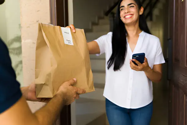 Imagen de cliente recibiendo pedido por transportista representando envío gratuito a partir de 20€ de compra en PutmanCompany